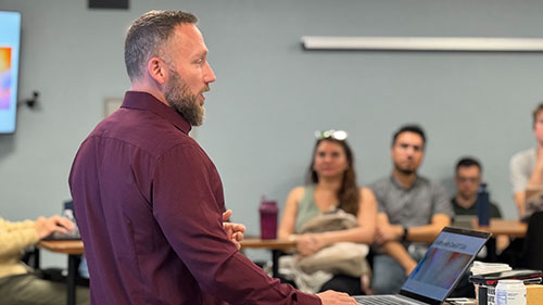 Keelan Schule presents GPT workflows and API integration details to a group of engaged IT professionals during SDSU's technical deep dive session.